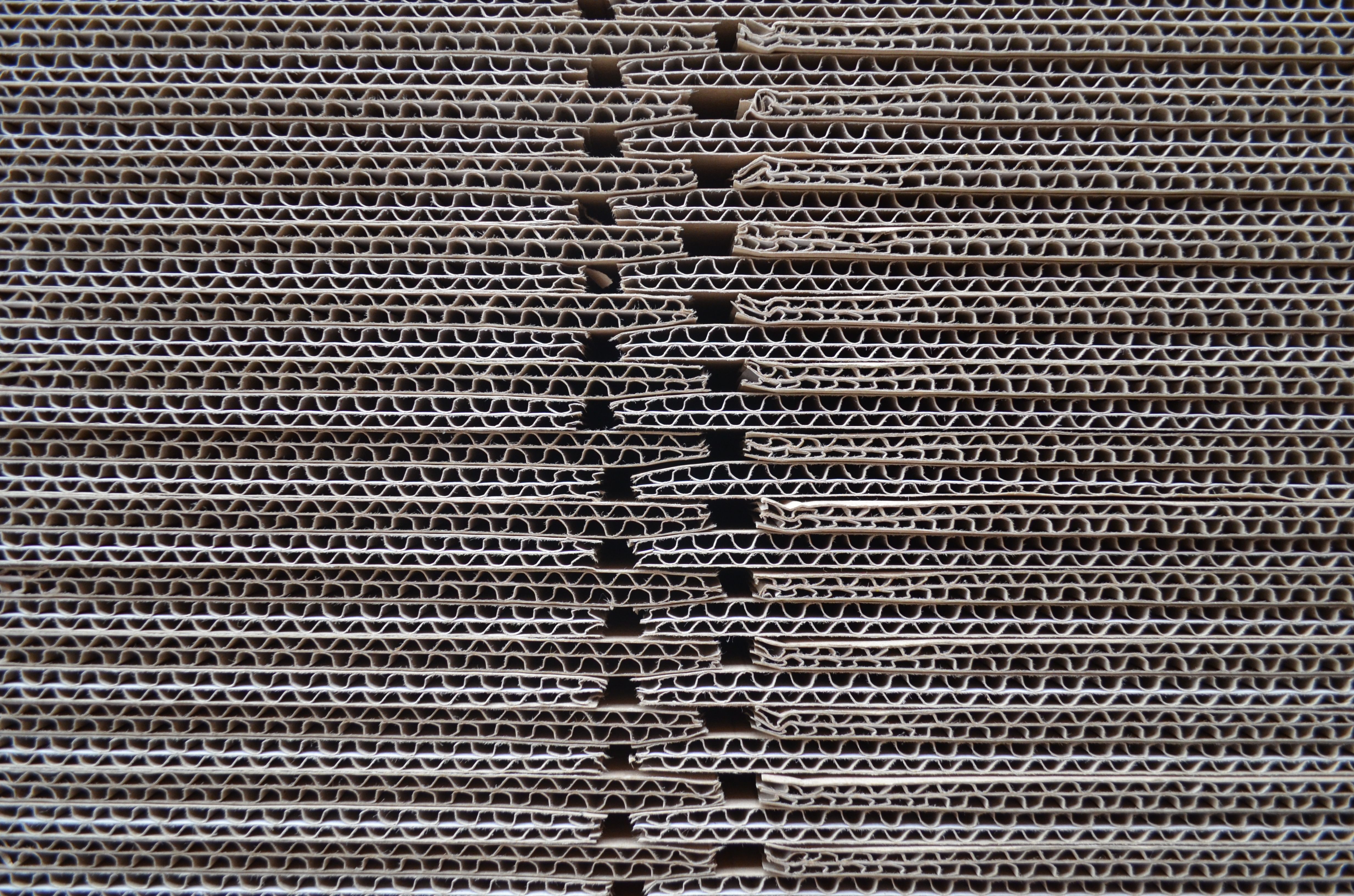 Close-up of corrugated cardboard stack showing the wavy fluted texture that gives boxes strength