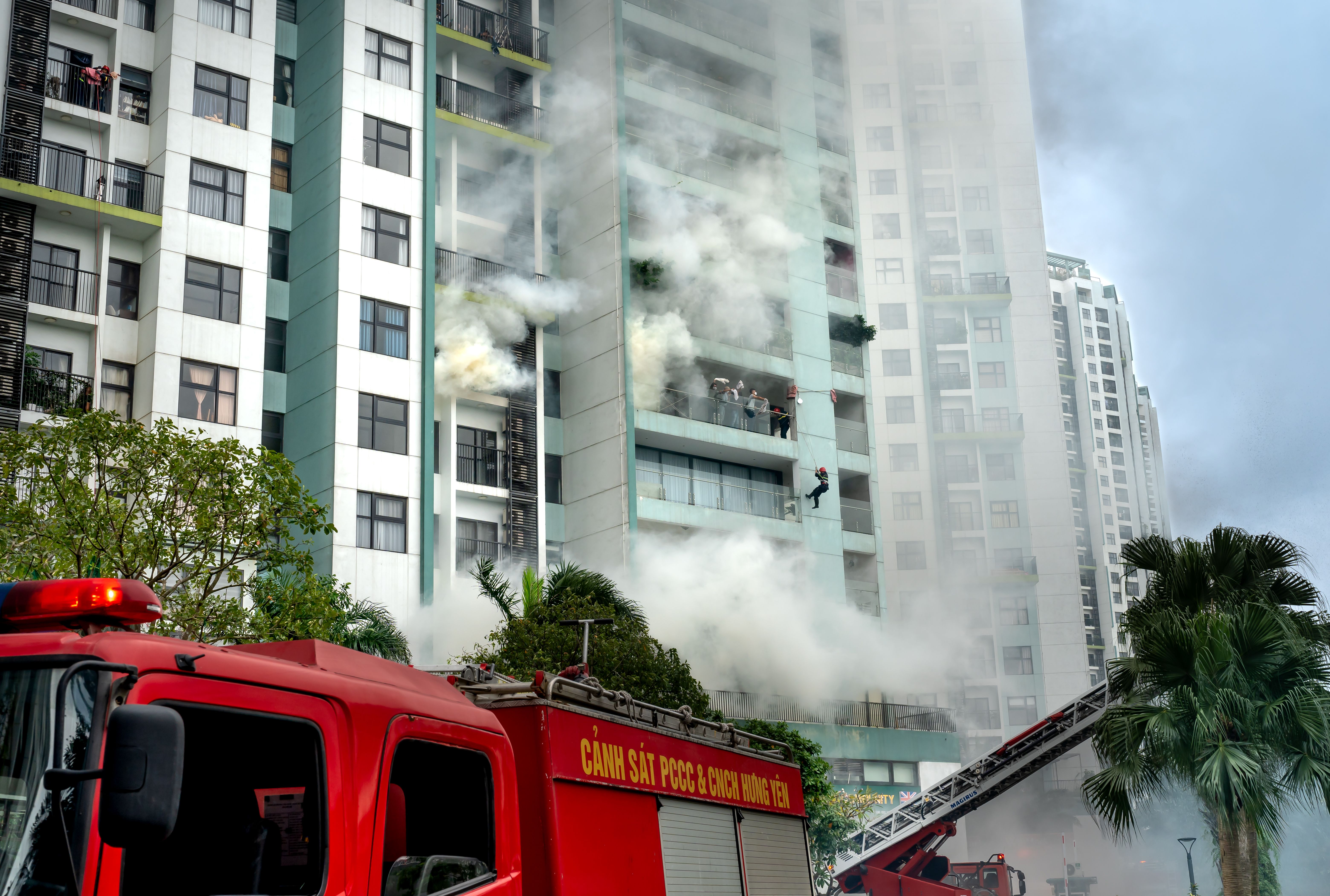 Firefighters responding to a building fire with emergency vehicles