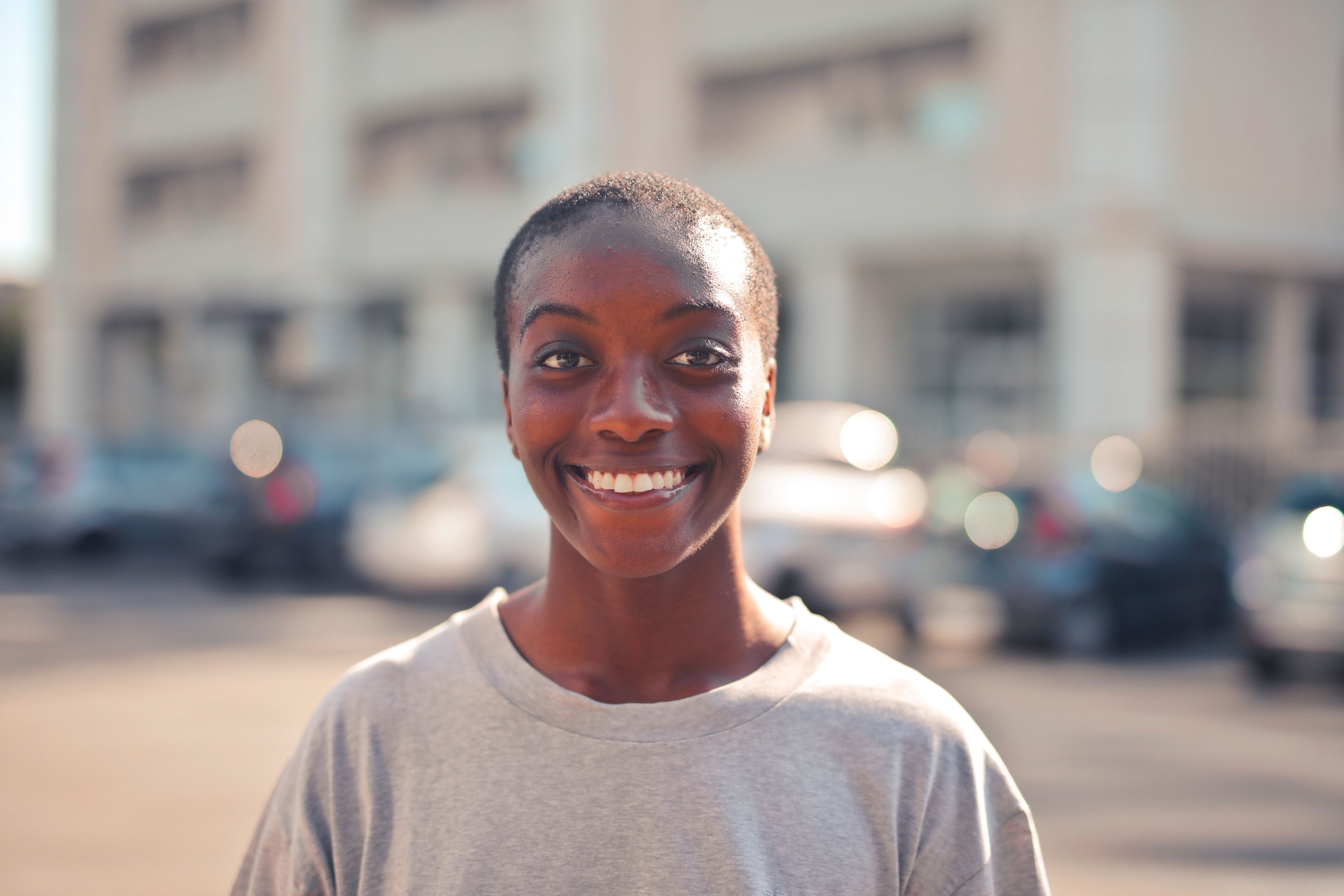 Smiling woman outdoors demonstrating an open and friendly facial expression.