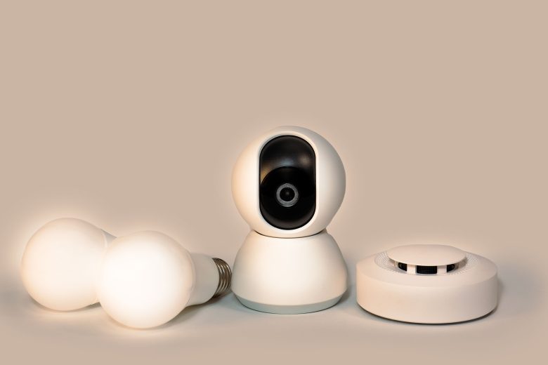 Modern smart home gadgets including a smoke detector and security camera