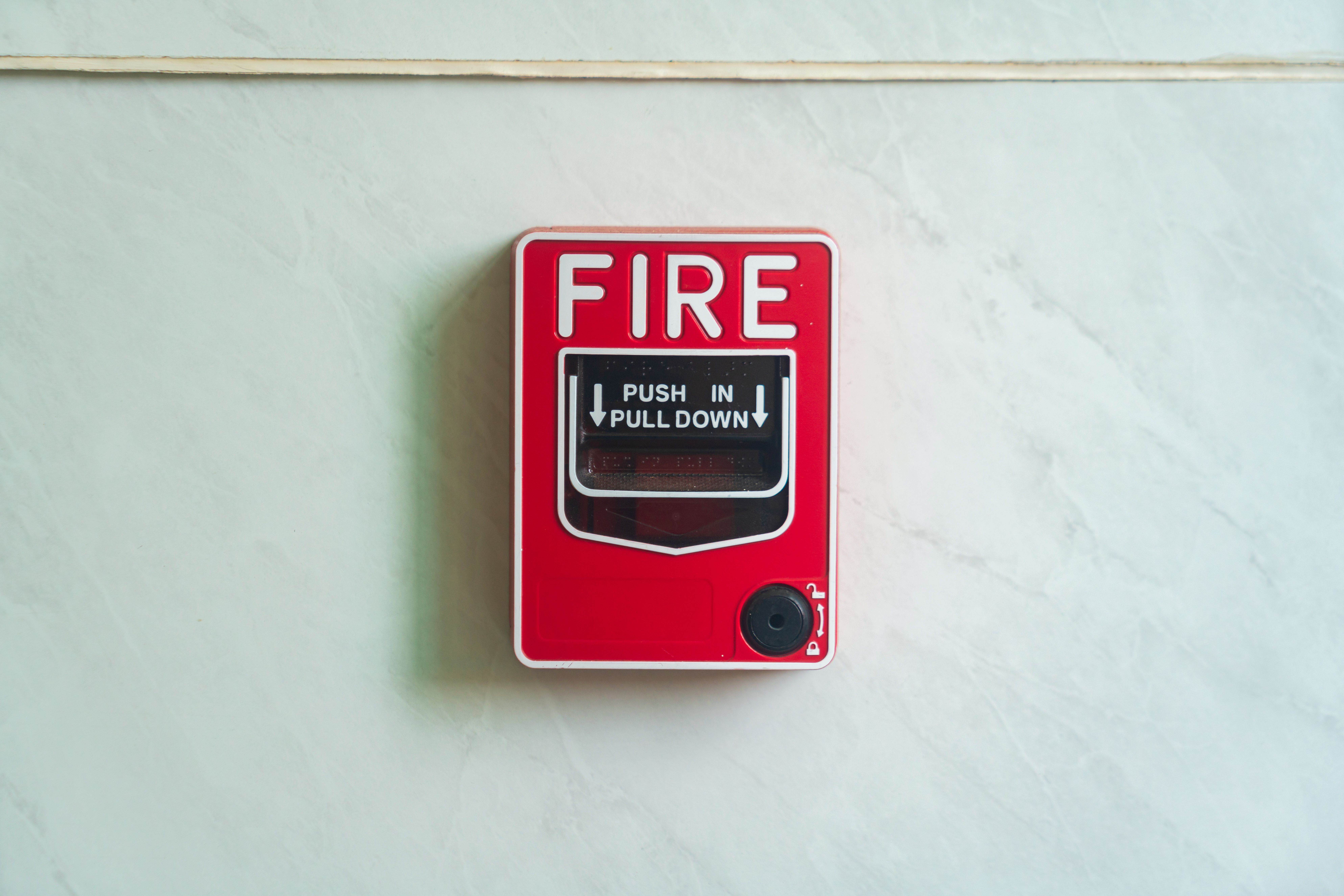 Red wall-mounted fire alarm device for emergency alerts