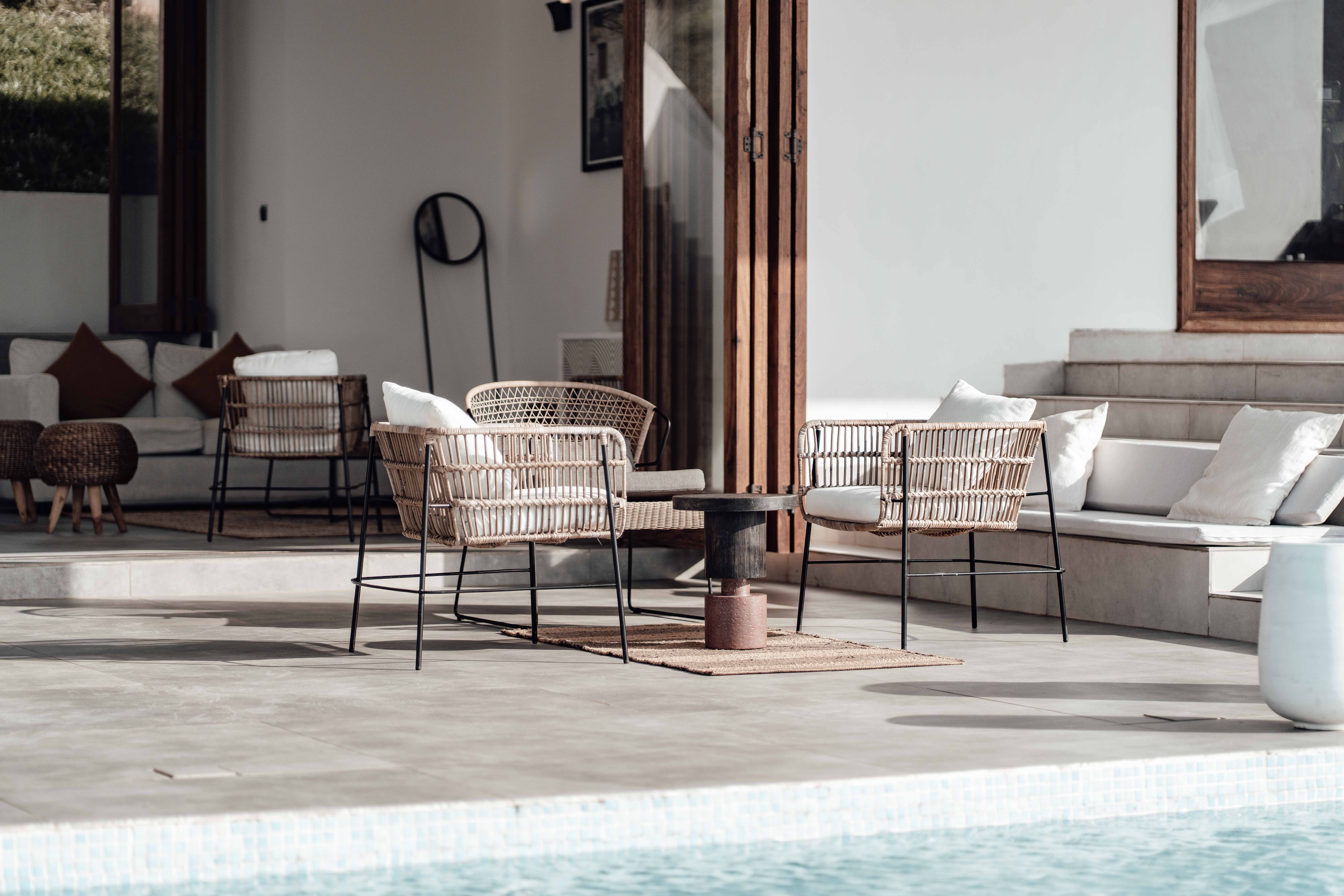 Modern wicker seating beside a pool in a stylish outdoor living area.